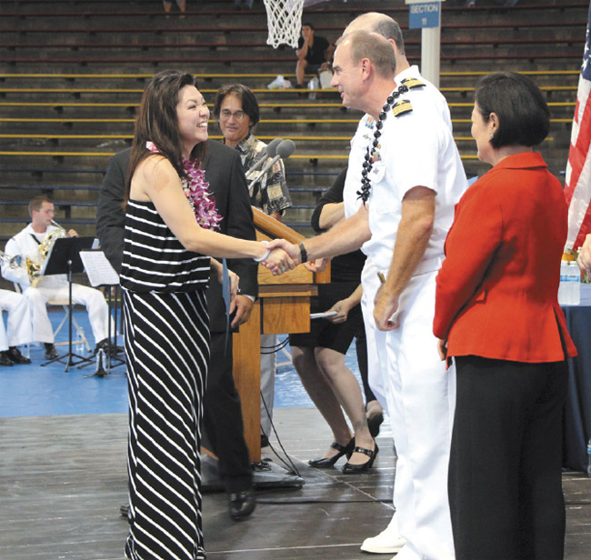 Shop 52 Electronics Measurement Equipment Mechanic Cheryl Yamanaka of Hawaii Kai is congratulated Aug. 9 by Shipyard Commander Brian Osgood, after she graduated from the 2013 Pearl Harbor Naval Shipyard Apprentice Program at a ceremony at Bloch Arena on Joint Base Pearl Harbor-Hickam. Yamanaka also earned an outstanding craftsman award as well as the Pearl Harbor Naval Shipyard National Association of Superintendents Superior Craftsman Award. Photo from David Tomiyama.
