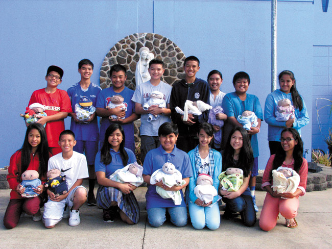 Seventh-graders at Our Lady of Good Counsel in Pearl City recently spent two weeks lugging around 5-pound bags of flour to simulate what might be like to have a baby to care for. The students were required to carry their flour babies with them everywhere they went - to class, sports practices or out with friends. The goal of the project was to give them an idea of how much time, work and responsibility are involved in caring for a child. Photo from Ginger Kamisugi.