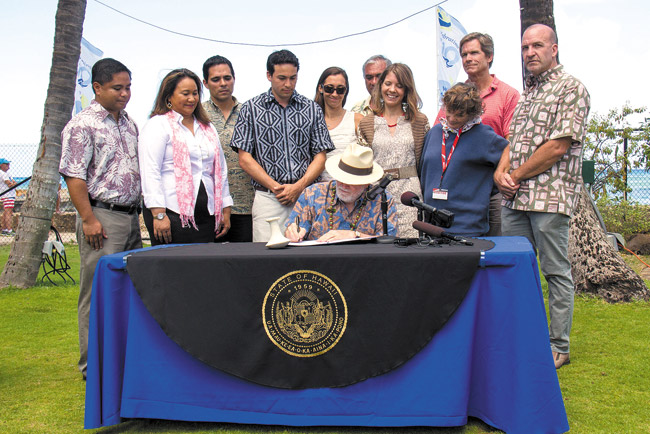 Kailua Rep. Chris Lee's climate change measure became law June 9, signed by Gov. Neil Abercrombie and witnessed by (from left) Reps. Henry Aquino and Karen Awana, Jesse Souki of DLNR, Rep. Lee, Nathalie Morrison of the state Office of Planning, BLNR chairman William Aila, state sustainability coordinator Jackie Kozak Thiel, Chip Fletcher of UH Manoa School of Ocean and Earth Science and Technology, Shannon Wood (front) of Windward Ahupua'a Alliance and Sam Lemmo of DLNR. Photo from the Governor's office.