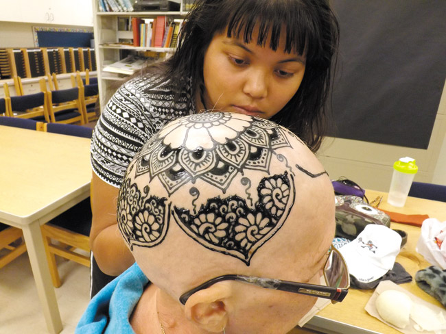 Kapolei High School librarian Nancy Espiritu gets her very own jagua (a non-toxic dye) crown, thanks to Kelsie Valentine, who has found her passion in helping those afflicted with hair loss because of cancer treatments. Photo from Kelsie Valentine.