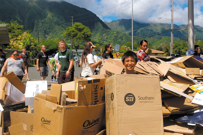 Sixth-grader Elijah Kekaula has a playful moment amid a mountain of corrugated cardboard, which was donated to Kahaluu Elementary School's Aloha 'Aina recycling drive in September. Area churches, school retirees, families and farmers — they all pitched in to clean up the community and help the school. Photo from Melanie Afualo.