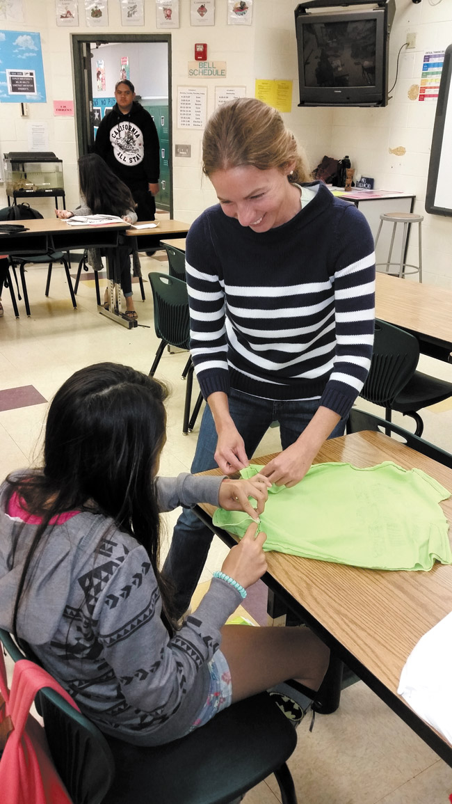 Michael Cahill works with a student March 6 on up-cycling a T-shirt into a reusable bag. Photo by Jennifer Kuwahara.