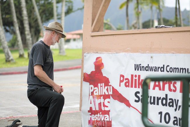 Paliku Arts Festival chairman Ben Moffat posts the sign for the annual celebration of hands-on creativity April 11 at Windward Community College. Photo by Bodie Collins, bcollins@midweek.com.