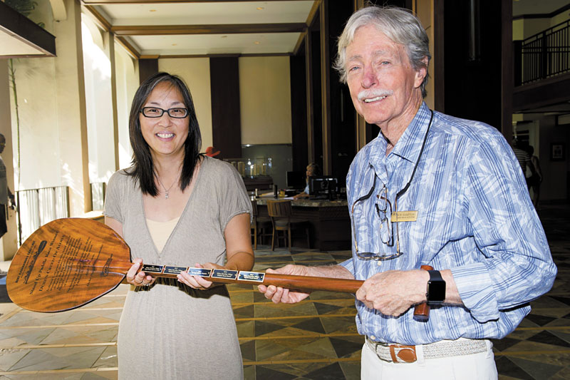 Caroline Hayashi, executive director of Waikiki Community Center, and Bob Hampton, Waikiki Beach Activities and Waikiki Community Center board member, with the trophy paddle