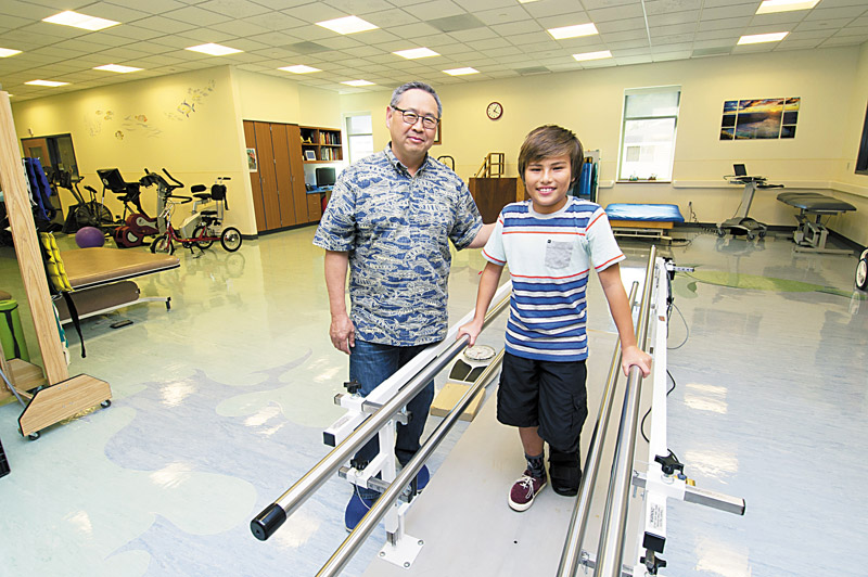 Dr. Craig Ono shows Jonathan Lau rehab bars to get him moving again