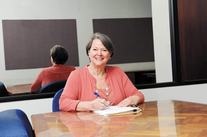 Becki Ward always sits at the head of the table while leading focus groups. Behind her is a two-way mirror
